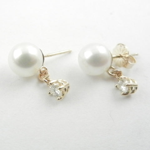 White pearls with a diamond dangle are a classic combination for these 14 kt yellow gold custom design stud earrings.